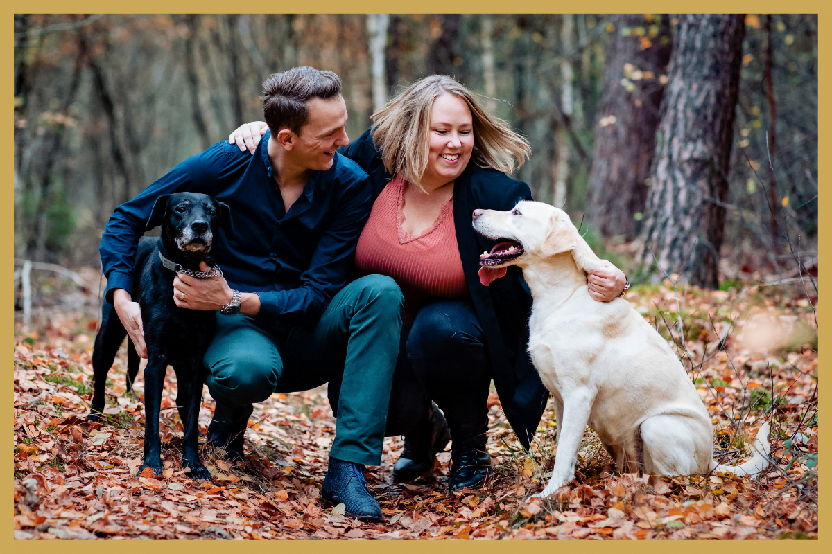 Twee gelukkig mensen met wee gelukkige labradors.